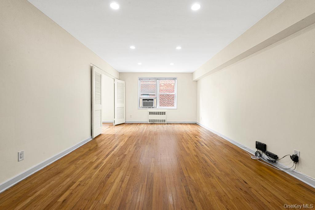 72-10 112th Street, Unit 5B Queens, NY 11375 - Photo 9 of 27 wooden floor in an empty room with a window
