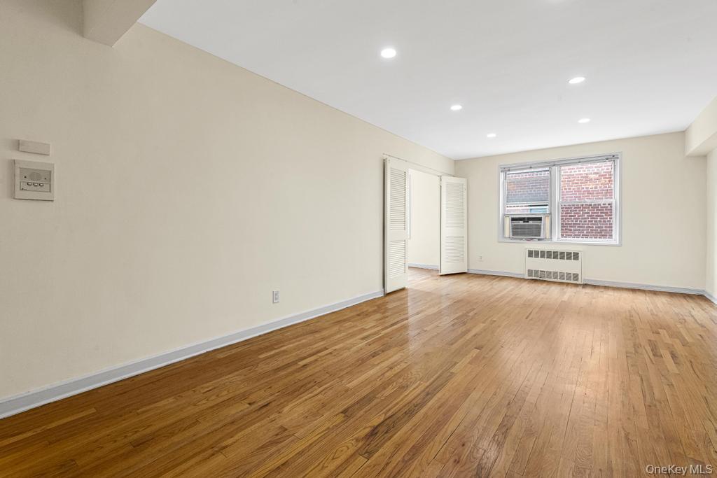 72-10 112th Street, Unit 5B Queens, NY 11375 - Photo 10 of 27 an empty room with wooden floor and windows