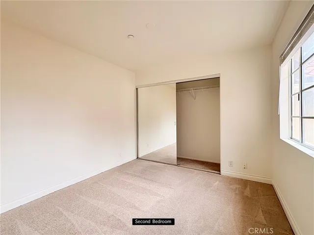 an empty room with windows and closet