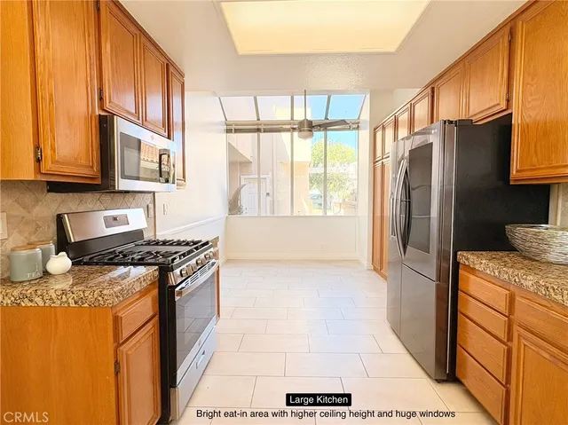 a kitchen with stainless steel appliances granite countertop a stove a sink and a refrigerator