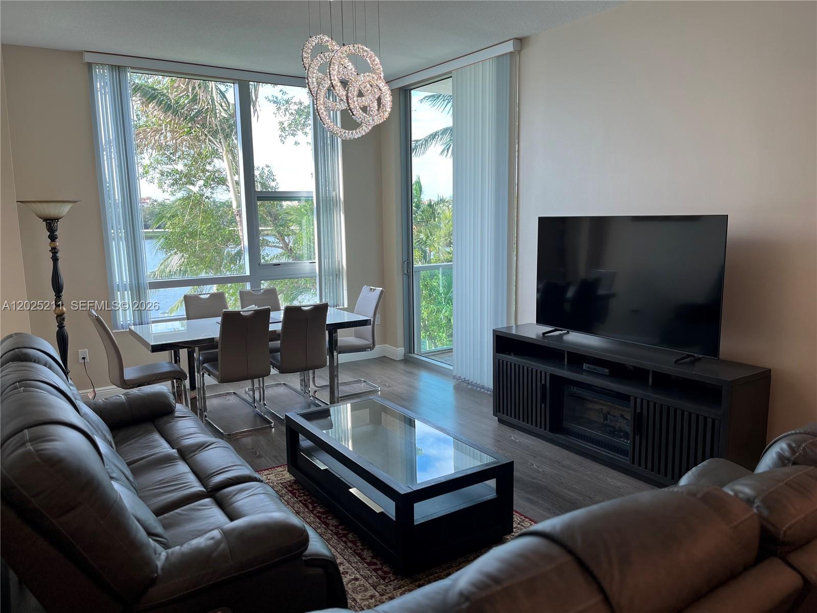 2681 North Flamingo Road, Unit 303S Sunrise, FL 33323 - Photo 3 of 18 a living room with furniture a flat screen tv and a large window