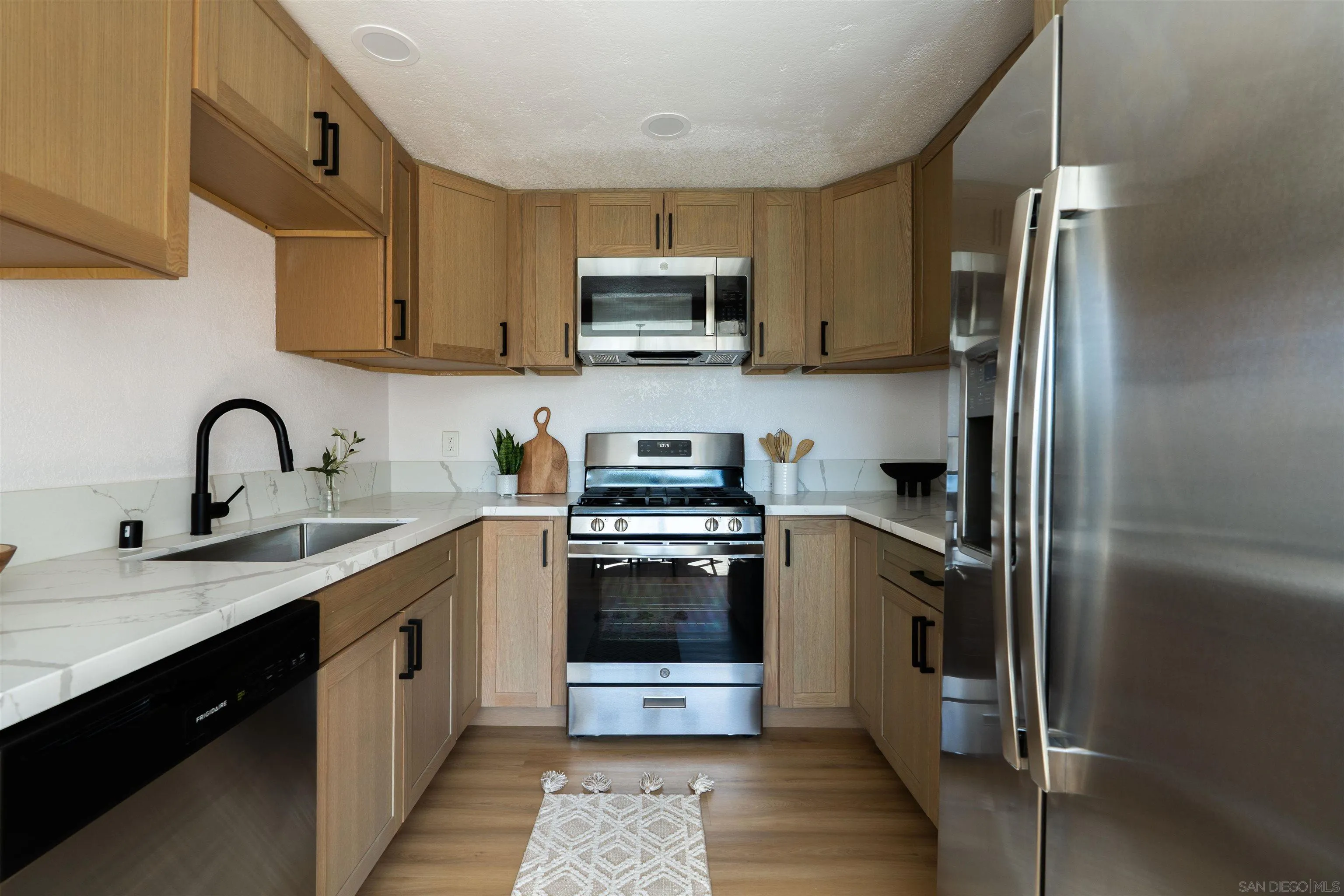 3101 King Arthurs Court Spring Valley, CA 91977 - Photo 19 of 40 a kitchen with stainless steel appliances granite countertop a refrigerator stove and sink