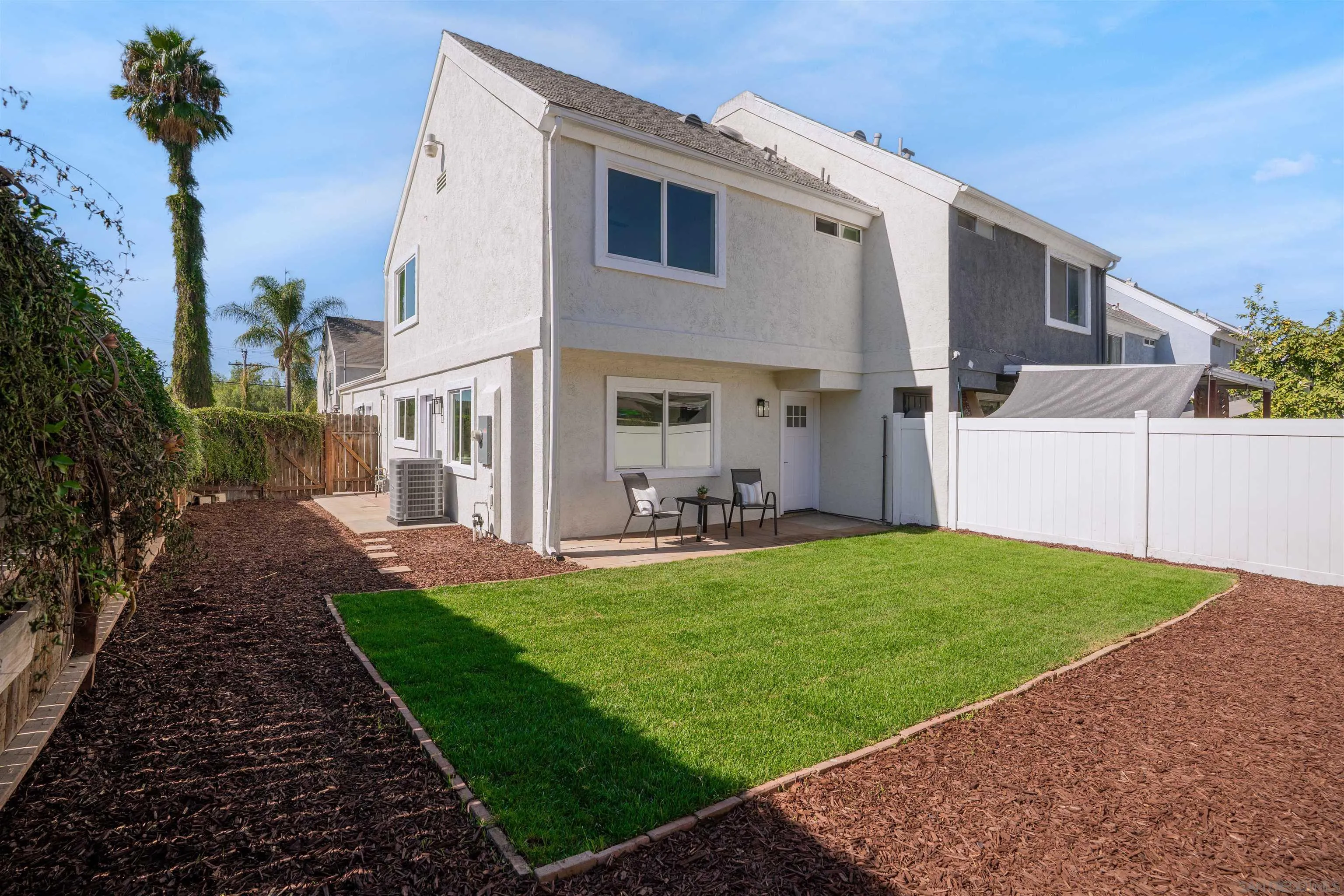 3101 King Arthurs Court Spring Valley, CA 91977 - Photo 31 of 40 a view of a white house with a yard potted plants and a bench