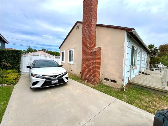 a car parked in front of a house with wooden fence