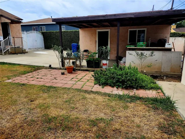 a view of a house with backyard and sitting area