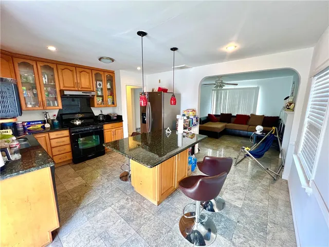 a living room with furniture flat screen tv and a large window