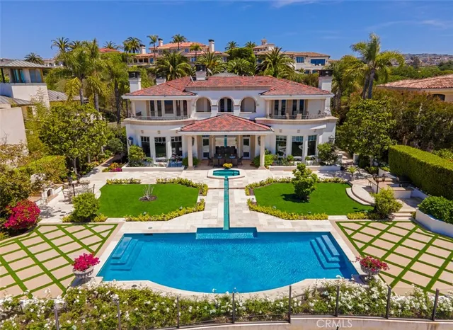 a view of a house with swimming pool lawn chairs and a yard