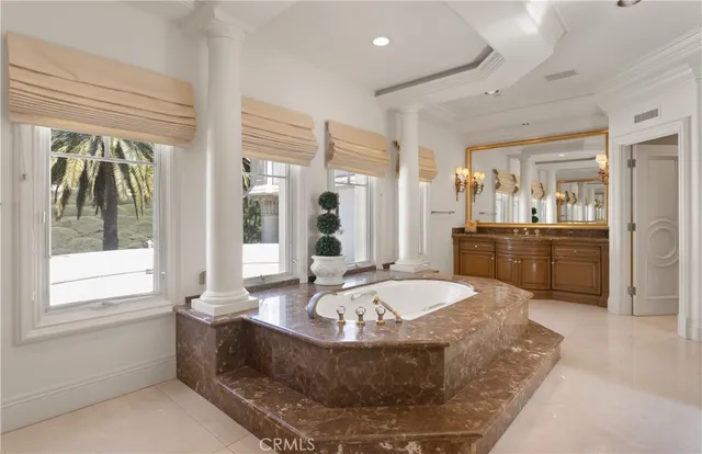 a spacious bathroom with a tub sink and mirror