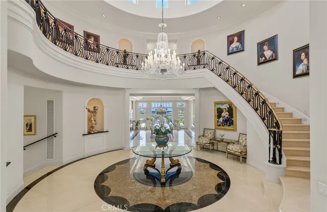 a living room with fireplace chandelier and a dining table