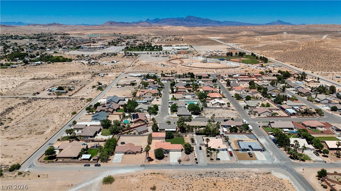 1272 Liston Avenue Logandale, NV 89021 - Photo 60 of 61 An aerial perspective reveals a quiet desert neighborhood nestled against a majestic mountain range.