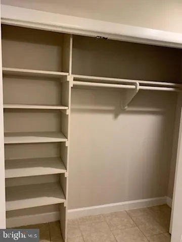 a view of walk in closet with empty racks