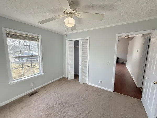 an empty room with windows and closet