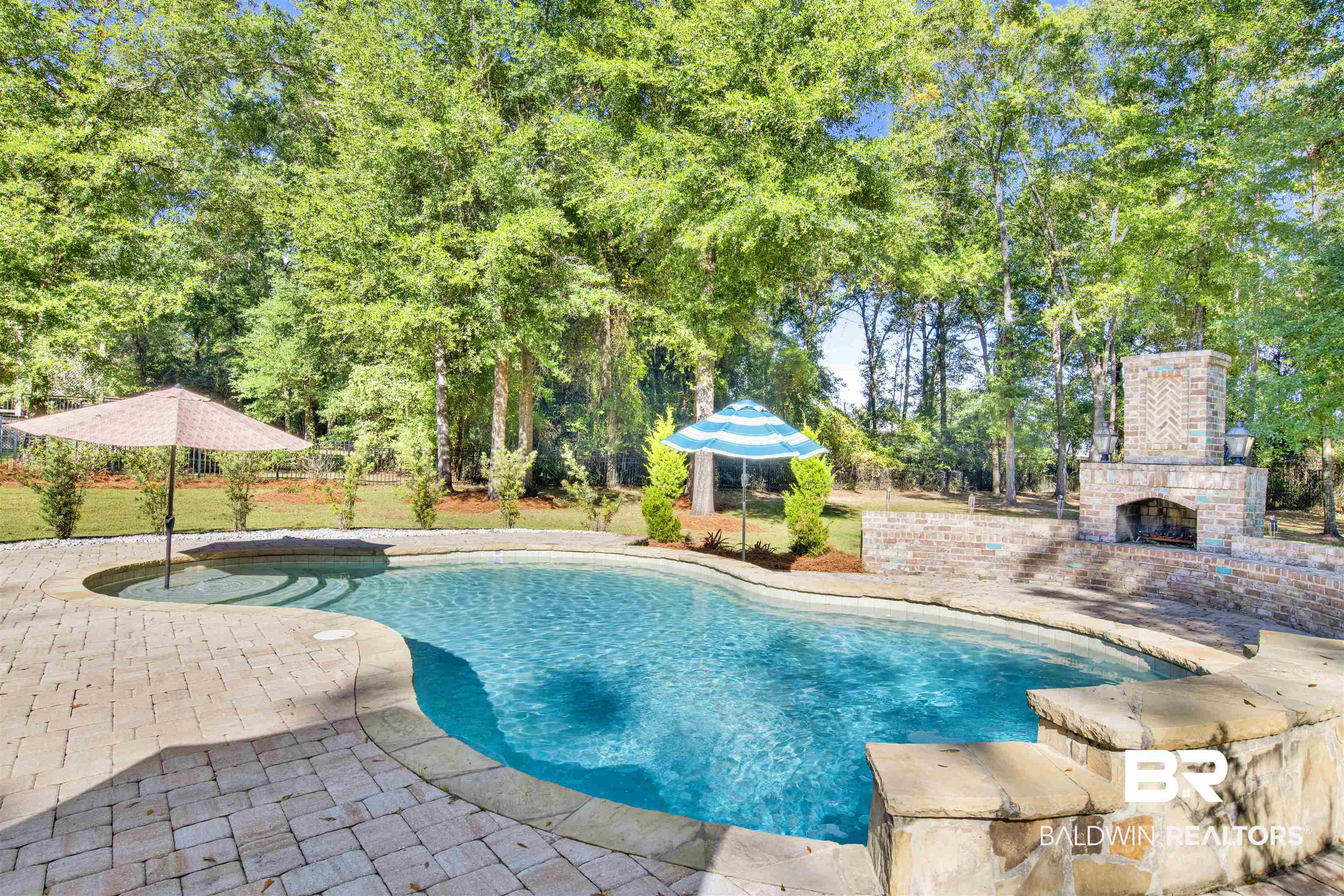 11116 Redfern Road Daphne, AL 36526 - Photo 10 of 46 Outdoor pool with a patio area, an outdoor brick fireplace, and view of scattered trees