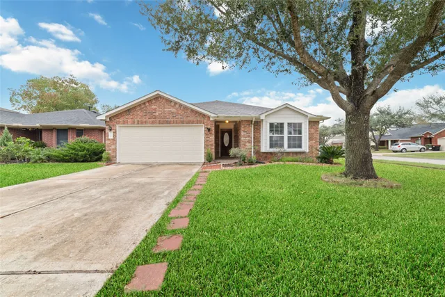 a front view of a house with a yard and trees
