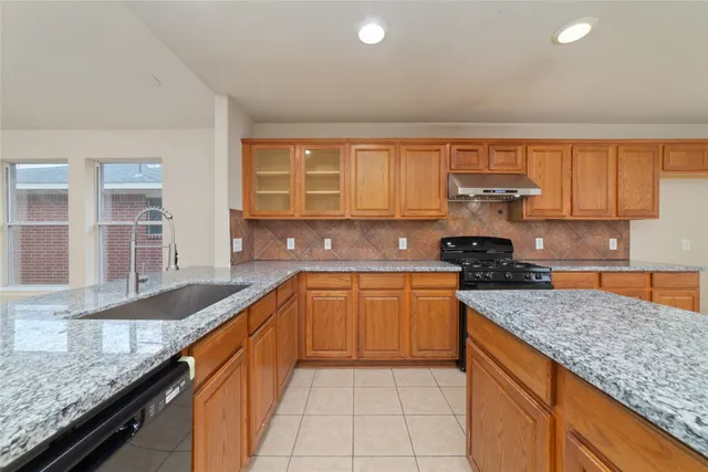 a kitchen with stainless steel appliances granite countertop a sink and a granite counter tops
