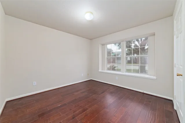 wooden floor in an empty room with a window