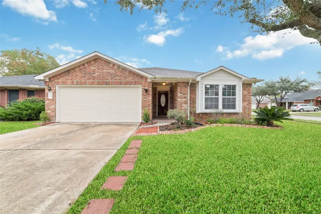 a front view of a house with a garden and yard