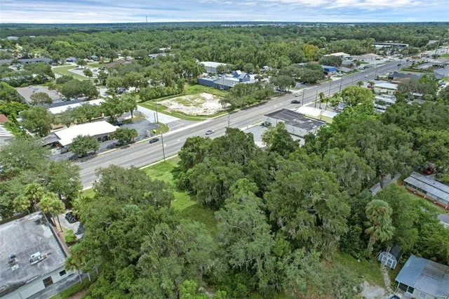 an aerial view of residential houses with outdoor space and trees