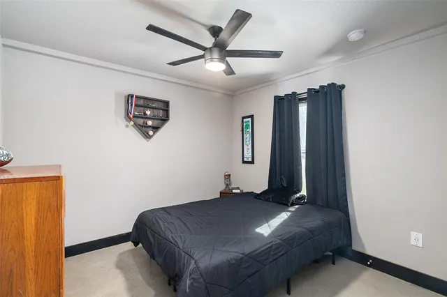 a bed room with a bed and a ceiling fan