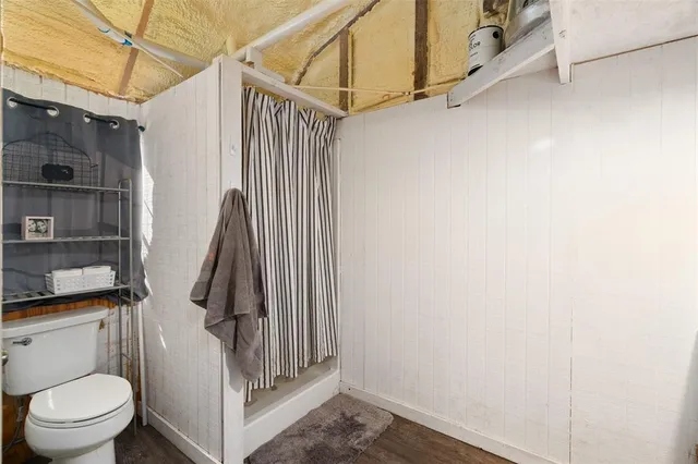 a bathroom with a toilet and a shower