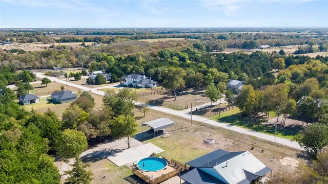 an aerial view of a house with yard swimming pool and lake view