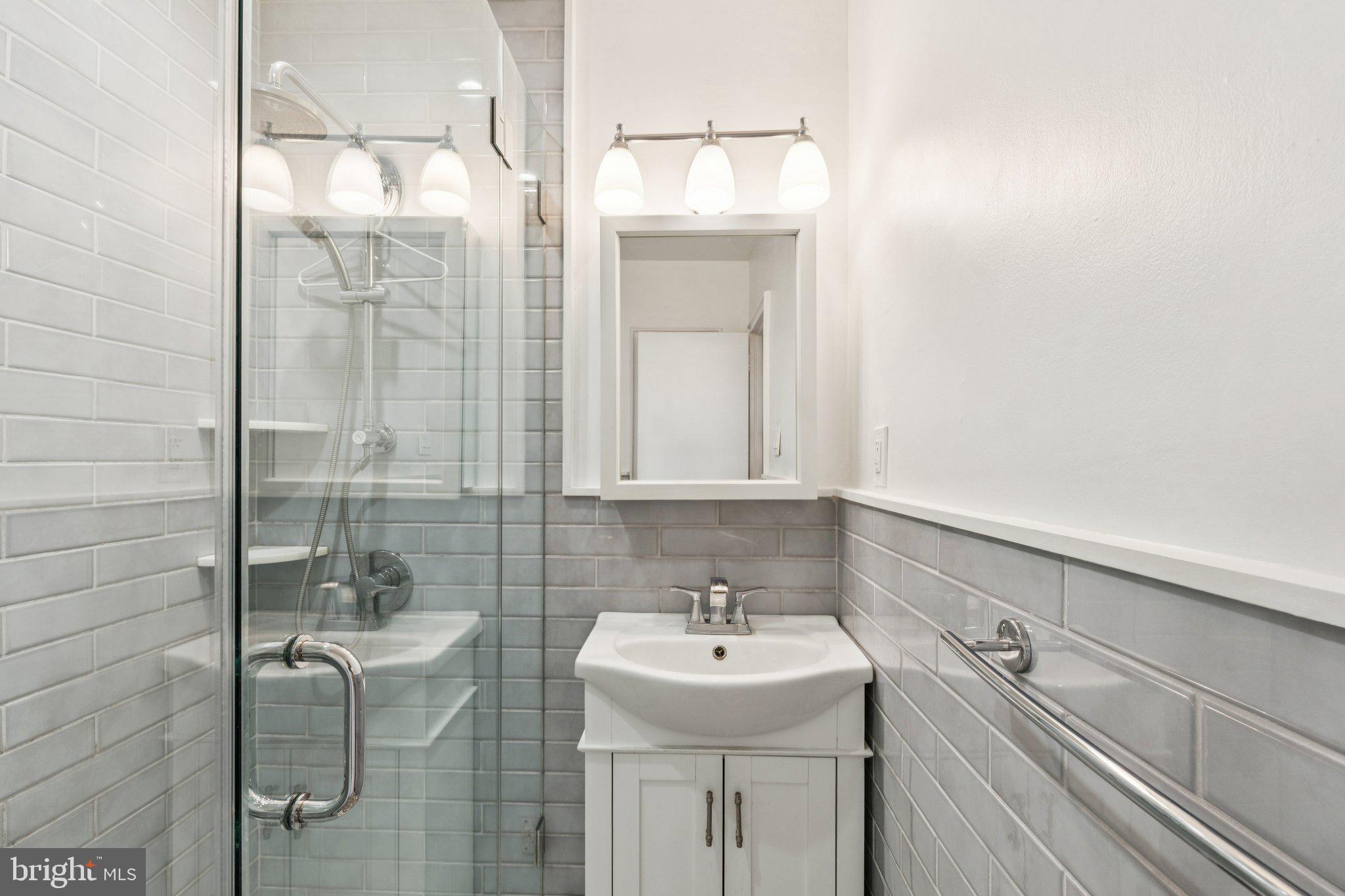 2601 Pennsylvania Avenue, Unit 449 Philadelphia, PA 19130 - Photo 11 of 18 a bathroom with a sink a shower and mirror