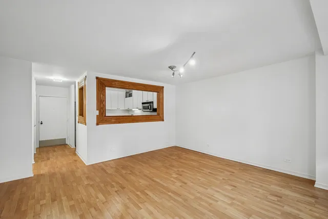 a view of empty room with wooden floor