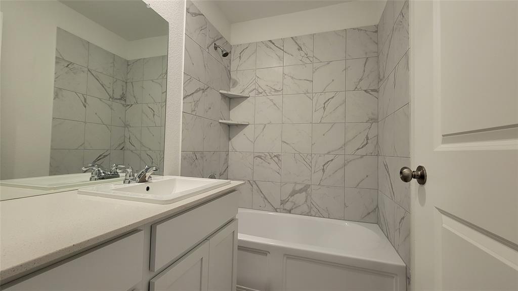 587 Avre Loop Kyle, TX 78640 - Photo 13 of 20 a bathroom with a sink a toilet and bathtub