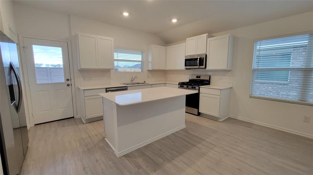 587 Avre Loop Kyle, TX 78640 - Photo 5 of 20 a kitchen with stainless steel appliances granite countertop a sink stove refrigerator and cabinets