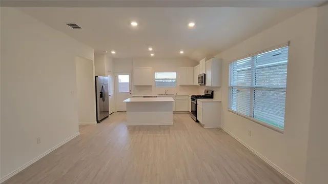 a kitchen with stainless steel appliances refrigerator sink and cabinets