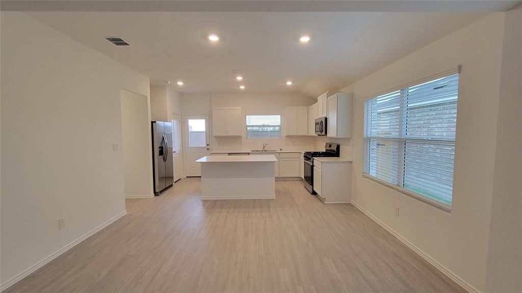 587 Avre Loop Kyle, TX 78640 - Photo 6 of 20 a kitchen with stainless steel appliances refrigerator sink and cabinets