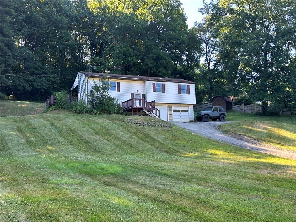 901 Prospect Road Evans City, PA 16033 - Photo 1 of 12 a view of a house with a big yard potted plants and a large tree