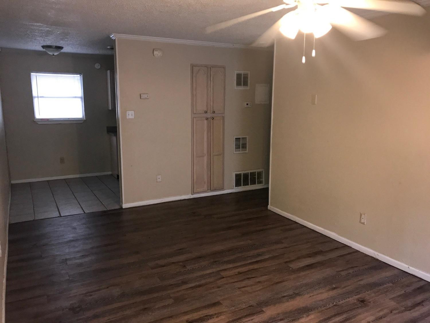 2202 15th Street, Unit 1 Lubbock, TX 79401 - Photo 3 of 6 an empty room with wooden floor and windows