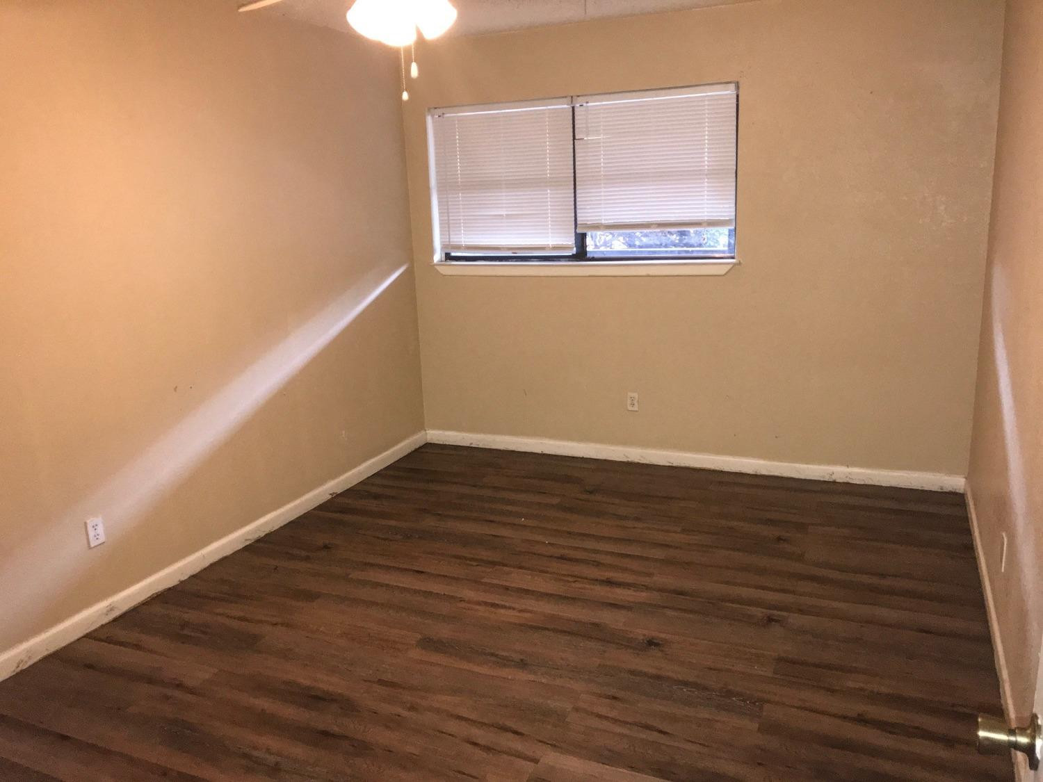 2202 15th Street, Unit 1 Lubbock, TX 79401 - Photo 4 of 6 a view of an empty room with wooden floor and a window