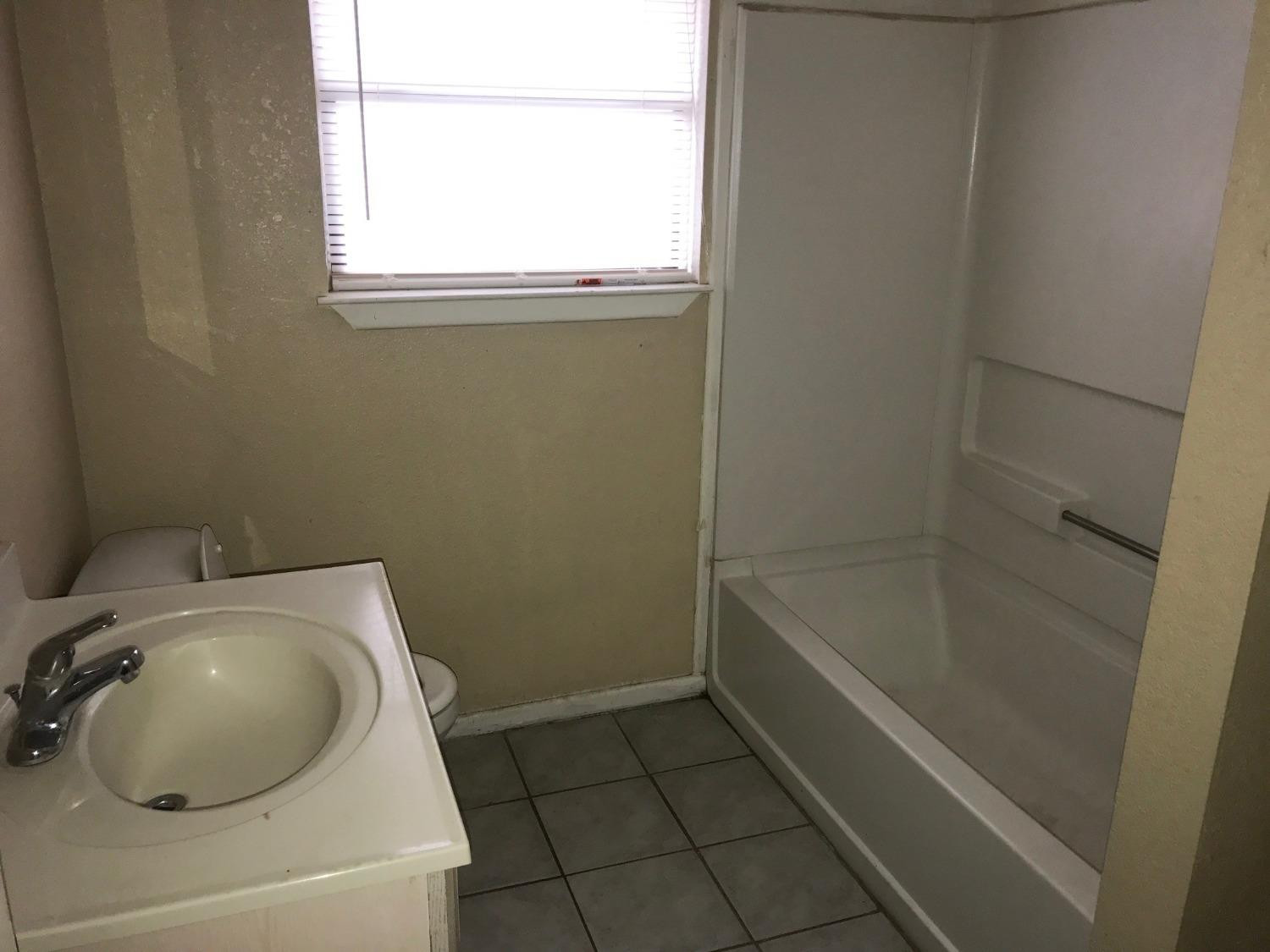 2202 15th Street, Unit 1 Lubbock, TX 79401 - Photo 6 of 6 a bathroom with a toilet and a sink