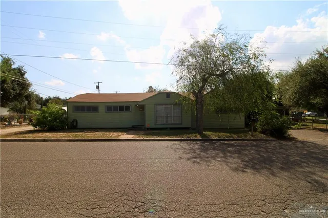 a front view of a house with a yard and trees