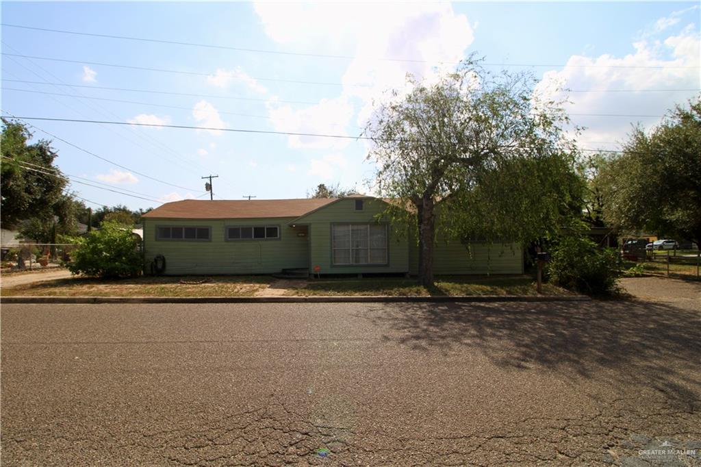 a front view of a house with a yard and trees