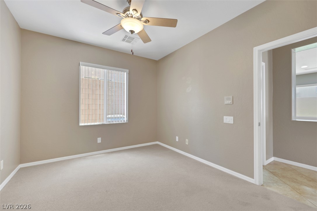 2501 Bechamel Place Henderson, NV 89044 - Photo 17 of 50 A well-lit bedroom features plush carpet flooring and a refreshing ceiling fan.