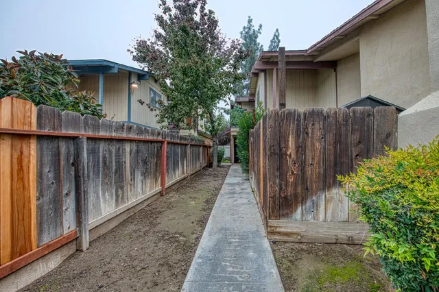 a side view of a house with wooden fence