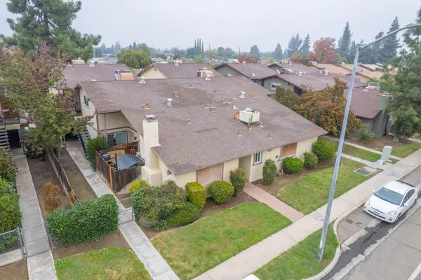 an aerial view of multiple houses with a yard