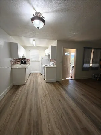 a kitchen with stove and wooden floor
