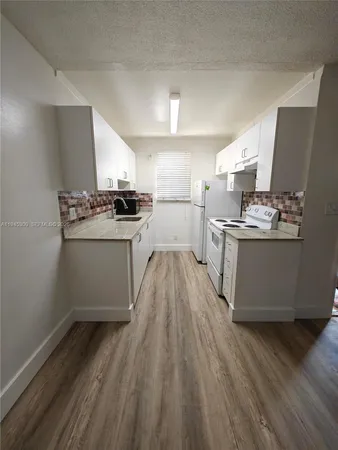 a kitchen with a stove a sink and a refrigerator
