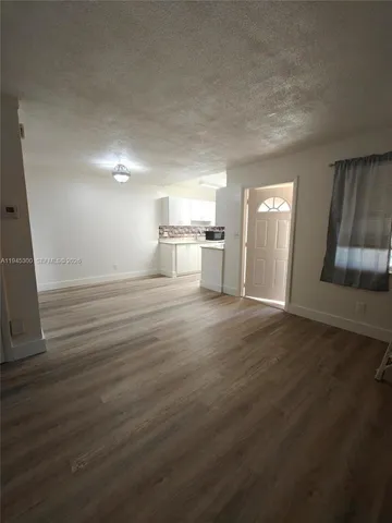 a view of a kitchen with wooden floor and electronic appliances
