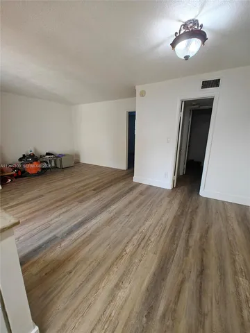a view of a room with wooden floor and ceiling fan
