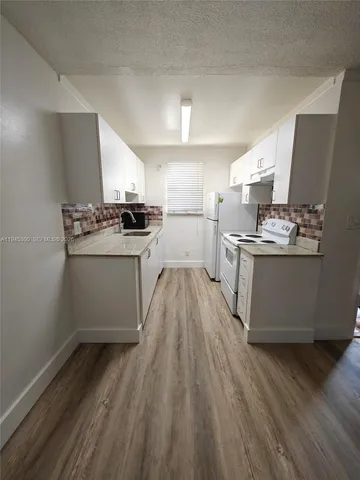 a kitchen with a stove a sink and a refrigerator