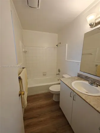 a bathroom with a granite countertop sink a toilet and bathtub