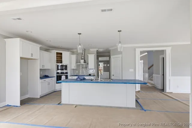 an empty room with windows and ceiling fan
