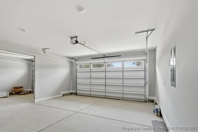 a view of an empty room with window and chandelier