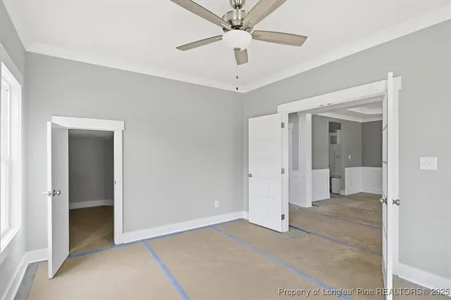 a view of an empty room with a window and a kitchen