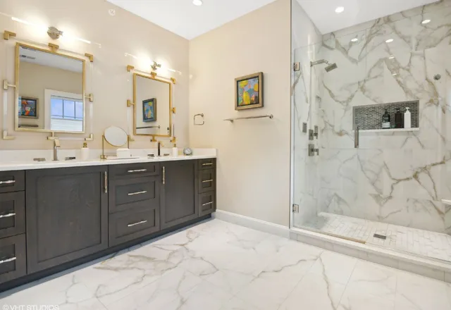 a bathroom with a double vanity sink mirror and shower
